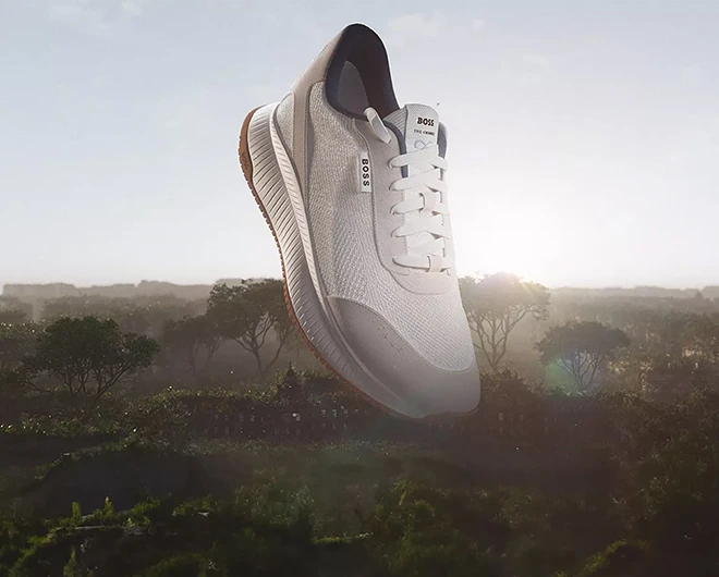 A white Hugo Boss sports shoe, woods in the background (photo)