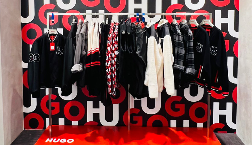 Display shelf with male’s clothing in front of a black, red and white background (photo)