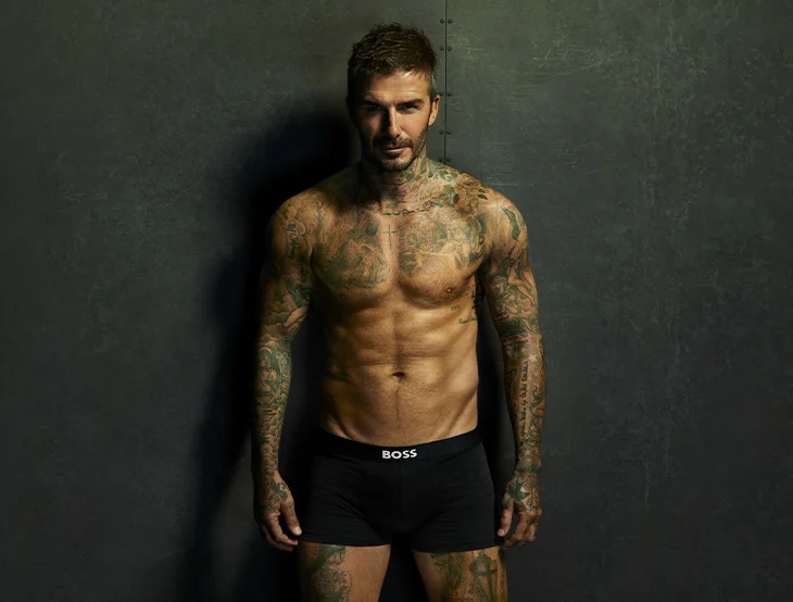 David Backham posing in front of a dark background wearing a Hugo Boss boxer shorts only (photo)