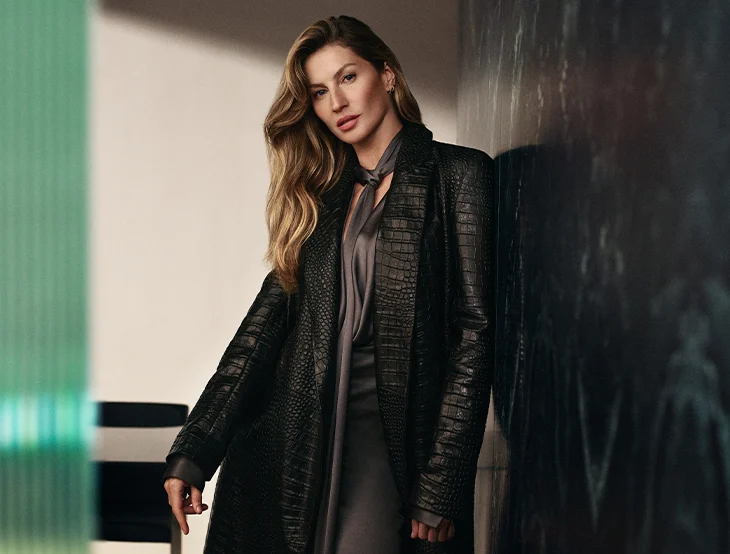 Giselle Bündchen posing in front of a dark background wearing a black leather jacket (photo)