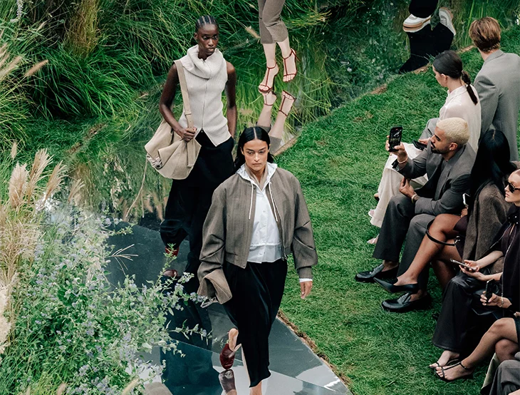 Two female models at a fashion show outside before an audience (photo)